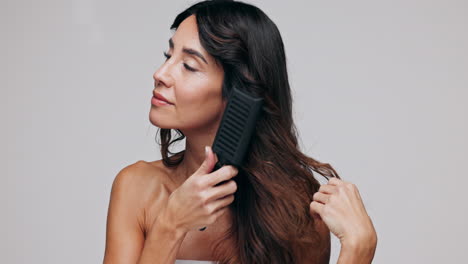 una mujer peinándose el cabello.