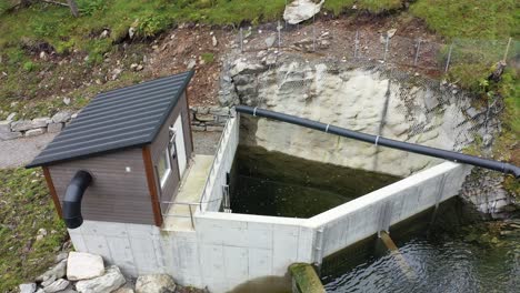 bajo nivel de agua en la presa de toma del río para la central hidroeléctrica markaani en vaksdal noruega - antena de montaña desde la toma