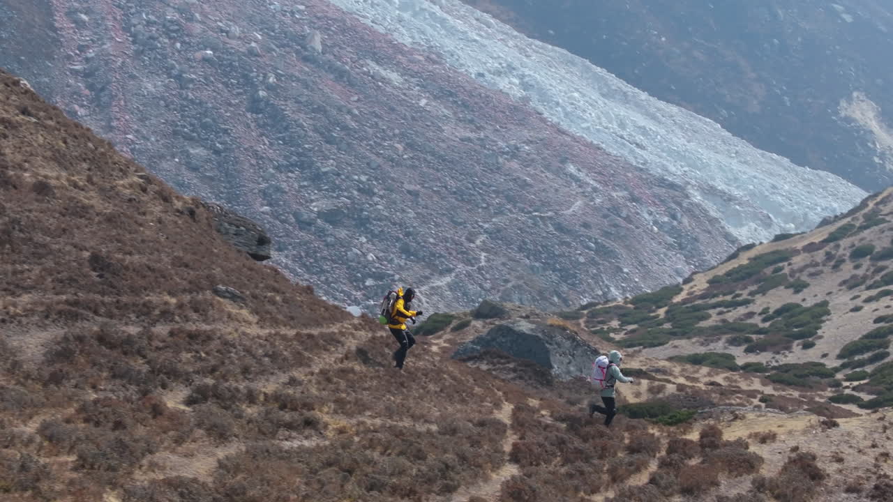 Tourists enjoy downhill running at Dingboche on Everest Base Camp trek. Scenic landscape, serene nature, and friendly atmosphere of Nepal for travel and tourism exploration drone shot
