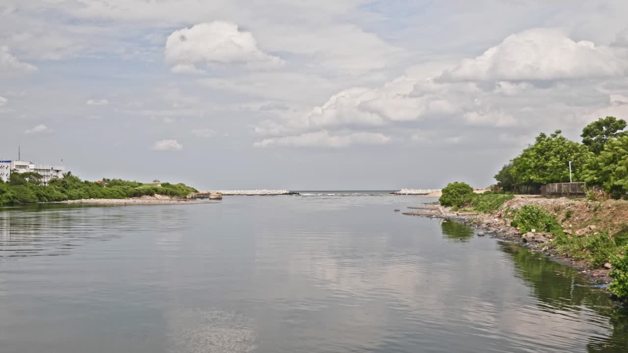 cooum river with Indian Coast Guard Regional Headquarters and clouds near marina beach, triplicane, chennai, tamil nadu, india. day time, zoom out shot, 4k.