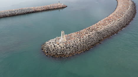 lighthouse on a levee breakwater aerial shot flying around france sete