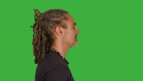 martial artist doing fighting training isolated on green screen background. energetic mid age rasta man boxing against camera.