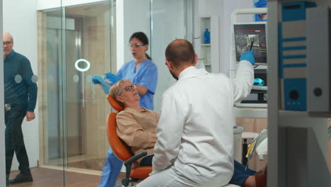 stomatologist pointing on digital screen explaining x-ray