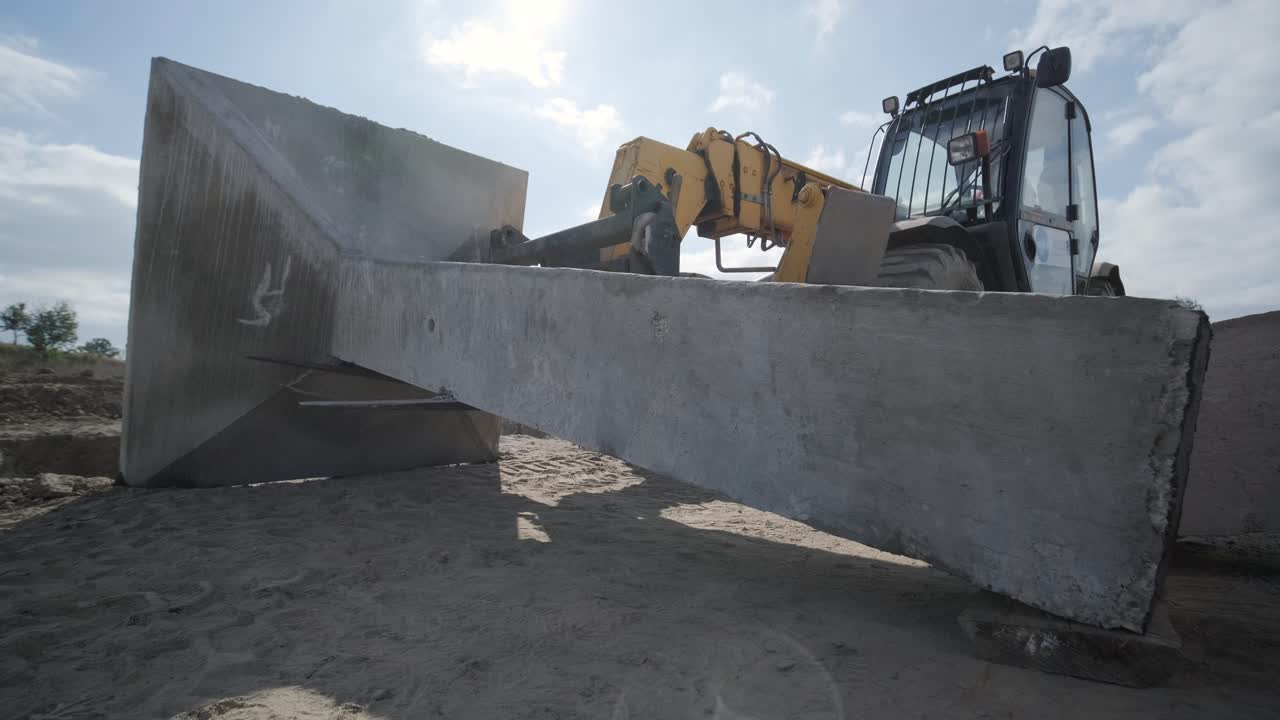 trabajo de excavación con tractor, el tractor levanta un pilar de hormigón