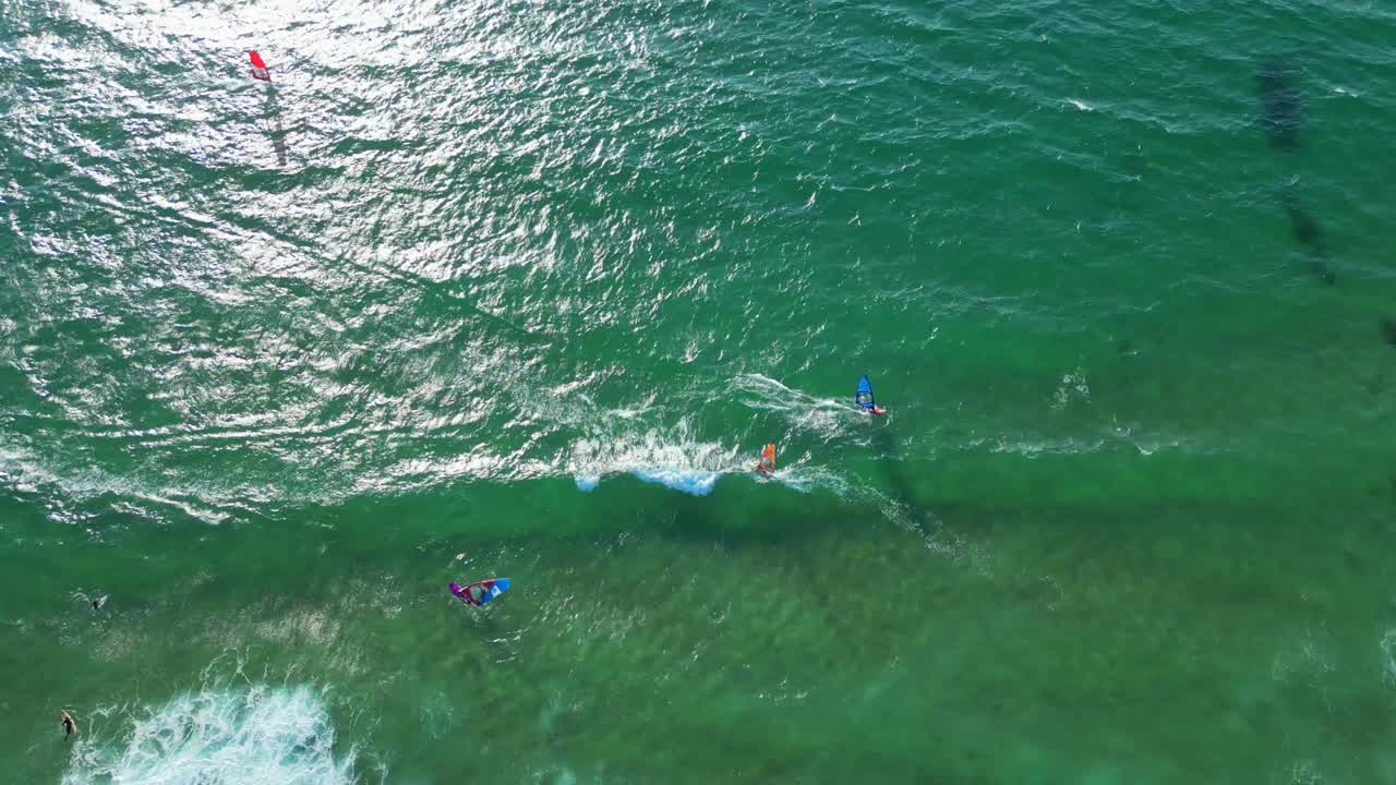 Aerial view from the sun reflected at sea with several windsurfers enjoying the good conditions of wind,Portugal
