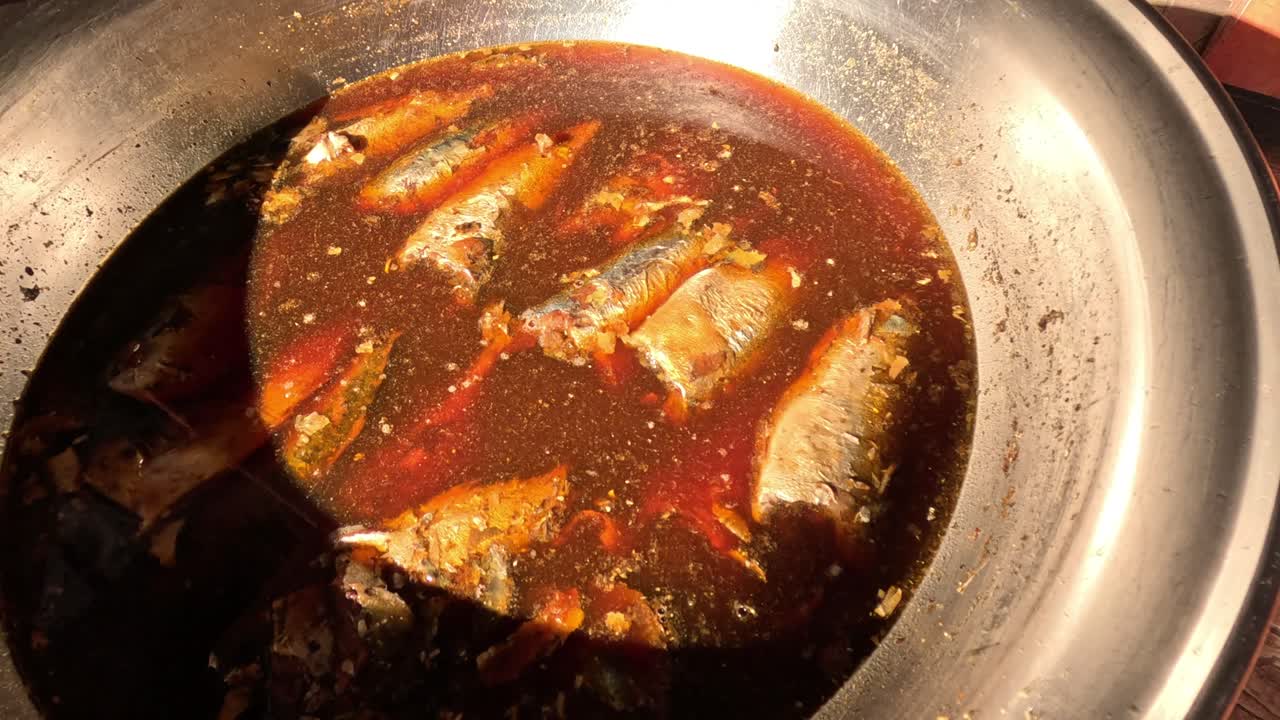 sardinas hirviendo en salsa en la estufa