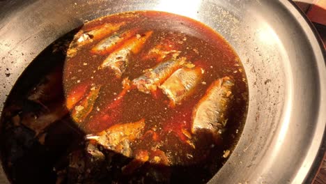 sardines simmering in sauce on stovetop