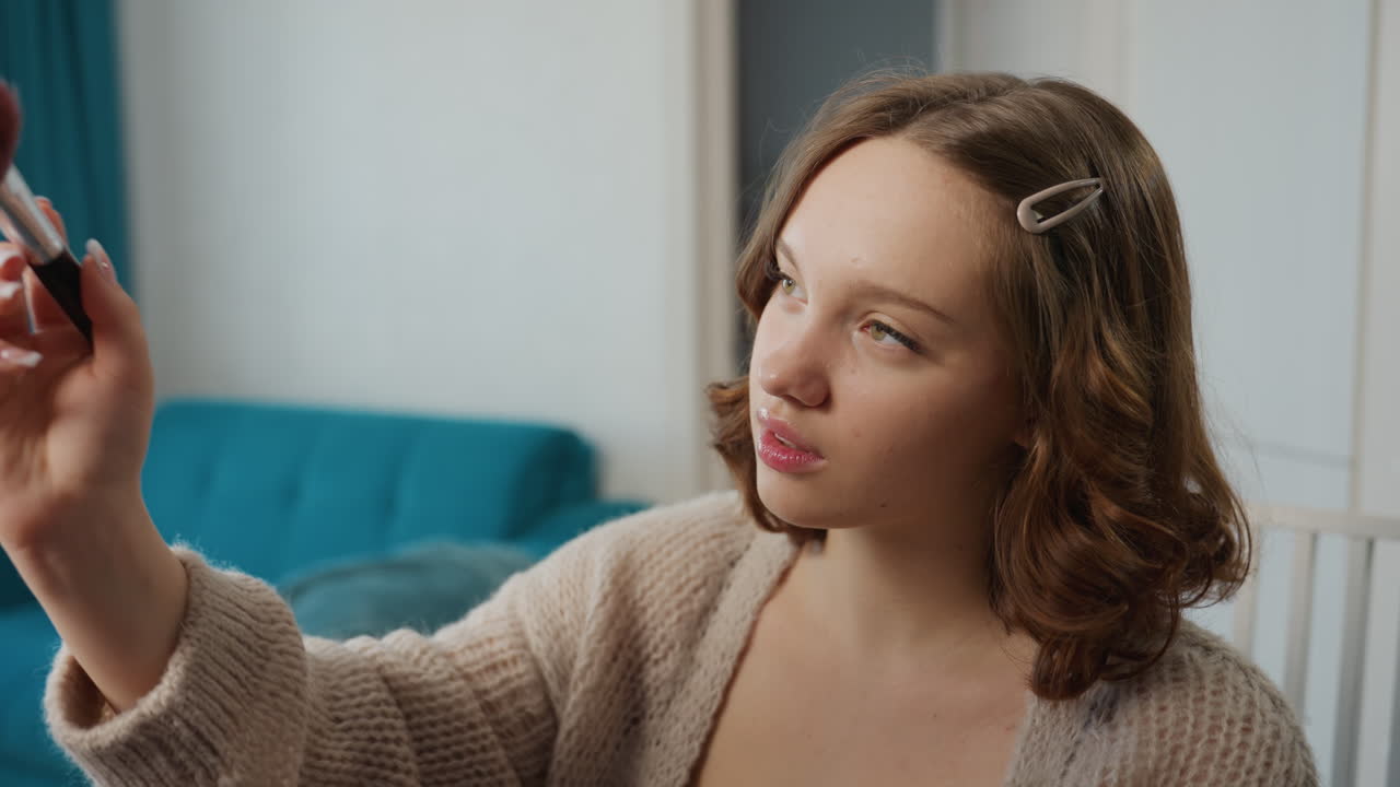 Caucasian Trainee Practicing Contour And Blush On Model, Serious Concentrated Expression, Palette And Brush In Hand, Soft Teal Sofa Backdrop, Instructional Practice In Casual Home Studio, Professional