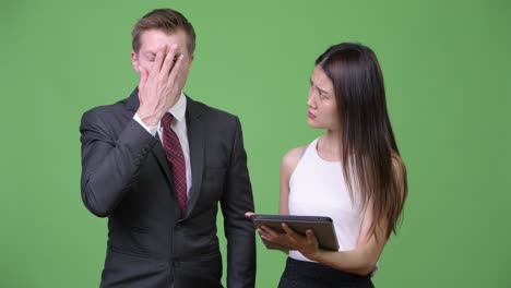 젊은 아시아 사업가 여성이 젊은 사업가에게 나쁜 소식을 보여줍니다.