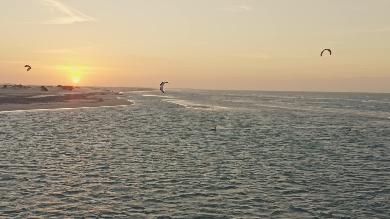 seguimiento de drones guriu kitesurfistas jugando en el horizonte del océano resplandor del atardecer