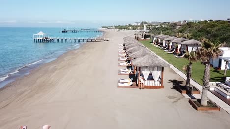 Vuelo-Rápido-Sobre-Camas-De-Lujo-Junto-A-La-Playa-En-Tiro-Aéreo-De-ángulo-Bajo