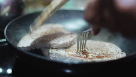 Turn-over-tuna-steak-while-cooking-in-pan-with-a-lot-of-steam-close-up