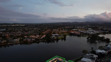 evening view of lake orr with waterfront apartments in varsity lakes - suburb in gold coast, queensland. wide drone shot