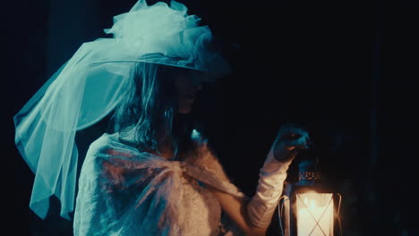 ethereal woman in white holding a lit lantern in the dark