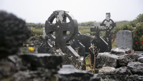 viejas lápidas en forma de cruces bajo la lluvia torrencial en un cementerio en un día nublado