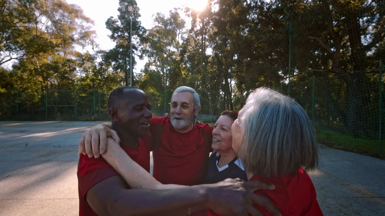 Group of seniors in circle hugging celebrating soccer game victory