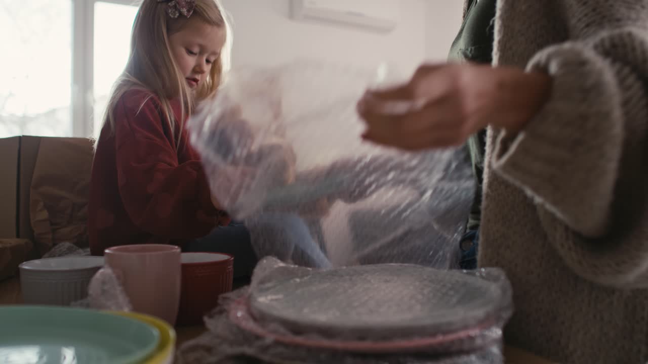 백인 어머니와 딸이 주방 물건을 포장하고 있습니다.