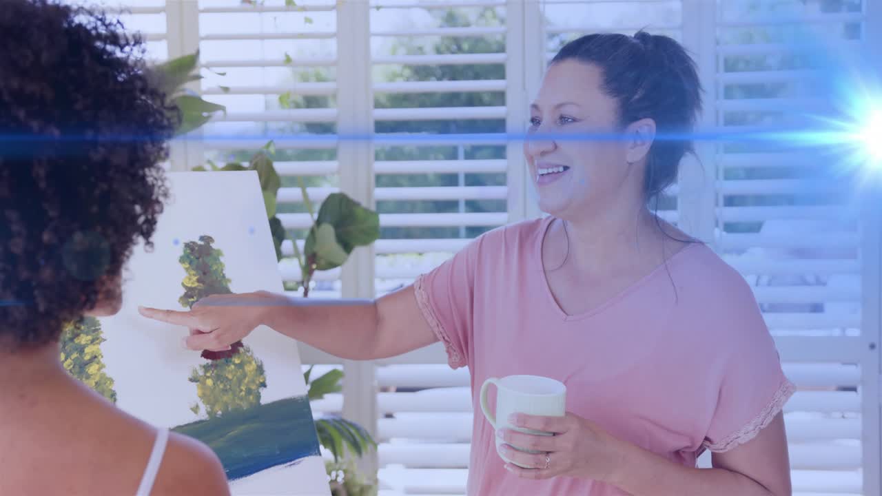 Woman in pink studying canvas, pointing and touching tree to guide art adjustments near easel