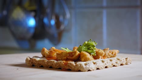 placing steamed broccoli on top of anabolic toast sandwich with cooked chicken meat and red hot buffalo wings dressing