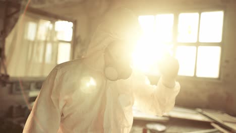 worker put on protective mask inside the ruined building exploring abandoned area