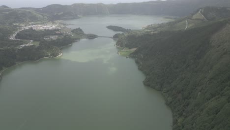 Lagos-De-Sete-Cidades-En-Portugal,-Rodeados-De-Exuberantes-Colinas-Verdes-Y-Un-Pueblo-Lejano,-Vista-Aérea