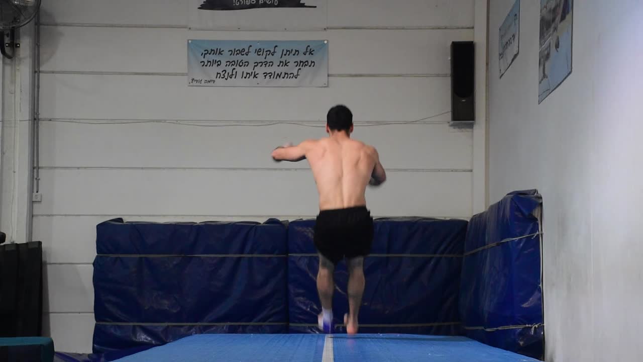 달리고 높은 전면 플립을 하는 남자의 스틸 샷은 60fps 슬로우 모션으로 그의 다리 근육과 상체 몸통 근육을 볼 수 있습니다.