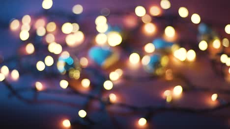 fotografía de cerca de la guirnalda con luces doradas y juguetes navideños en fondo de color. concepto navideño. decoración del hogar. hermoso bokeh