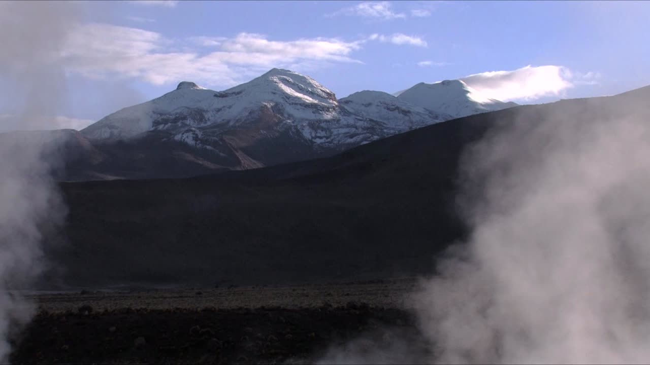 vapor que sale de los géiseres el tatio en las montañas nevadas de los andes en chile