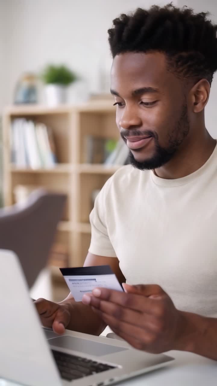 Giovane uomo afro che fa acquisti online usando una carta di credito nel suo ufficio a casa