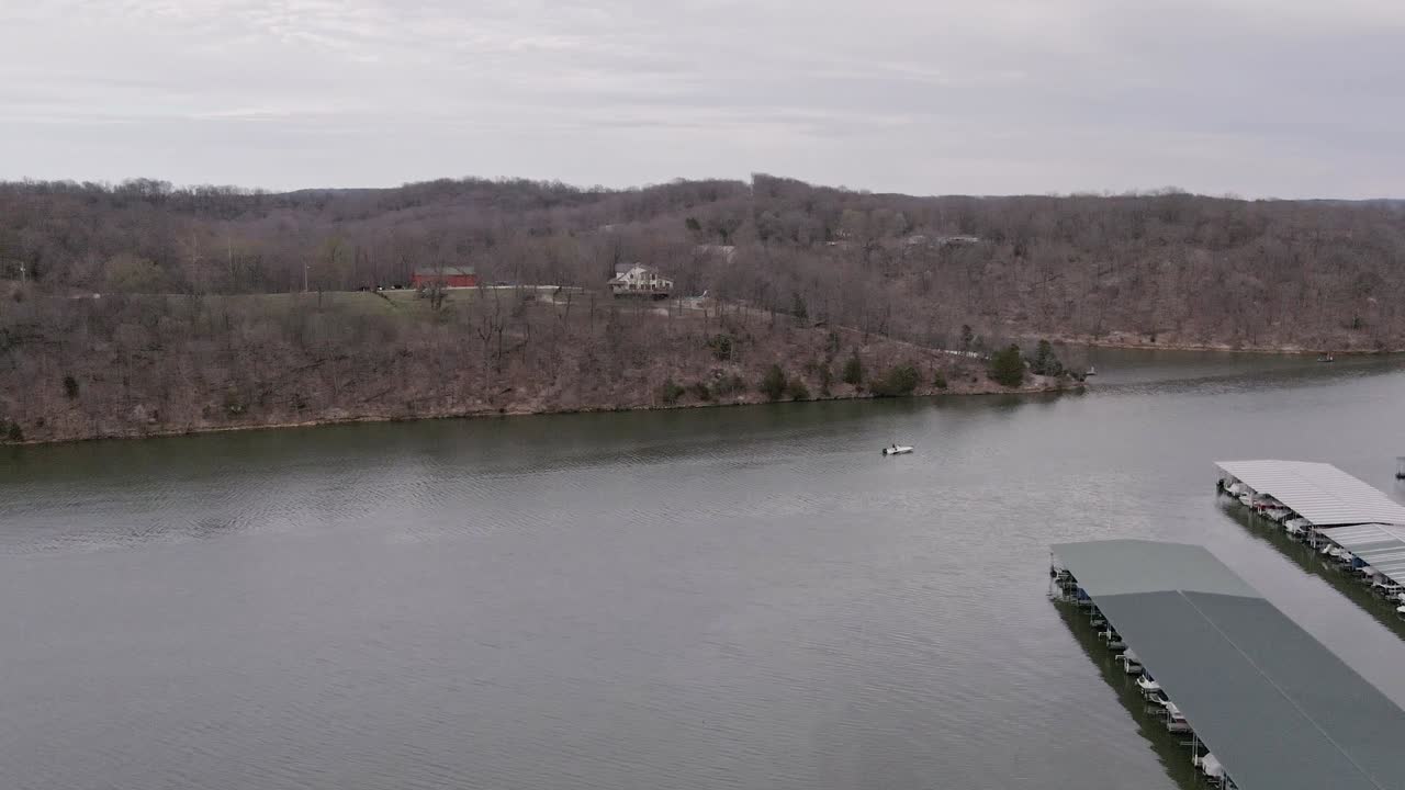 Lone boat passing marina on lake