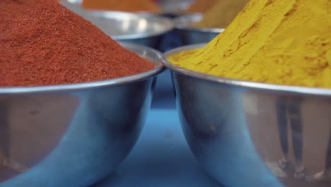 pull back close up through colourful piles of mixed herbs - spices in outdoor store market scene in india goa palolem beach