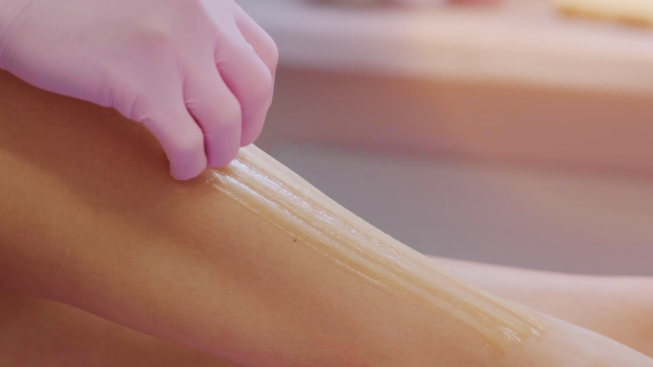 Female legs depilation by honey or sugar pasta. Sugaring hair removal. Beauty concept. Sugaring. Epilation process. Legs.