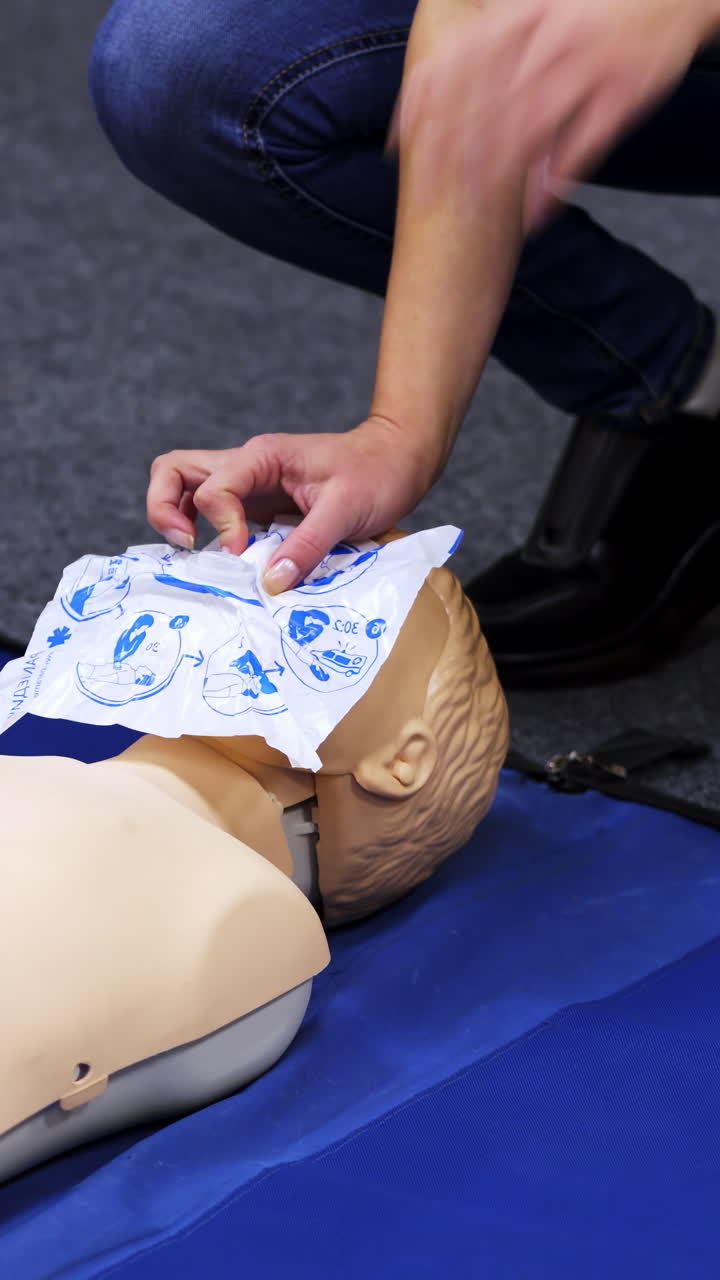 First aid cardiopulmonary resuscitation course. Instructor demonstrating cardiopulmonary resuscitationon mannequin at first aid training course. Vertical video