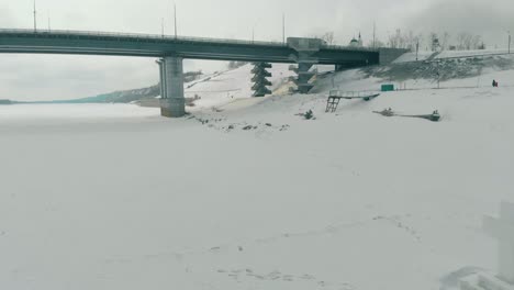 Eiskreuz-Auf-Gefrorenem-Fluss-An-Der-Transportbrücke,-Luftaufnahme