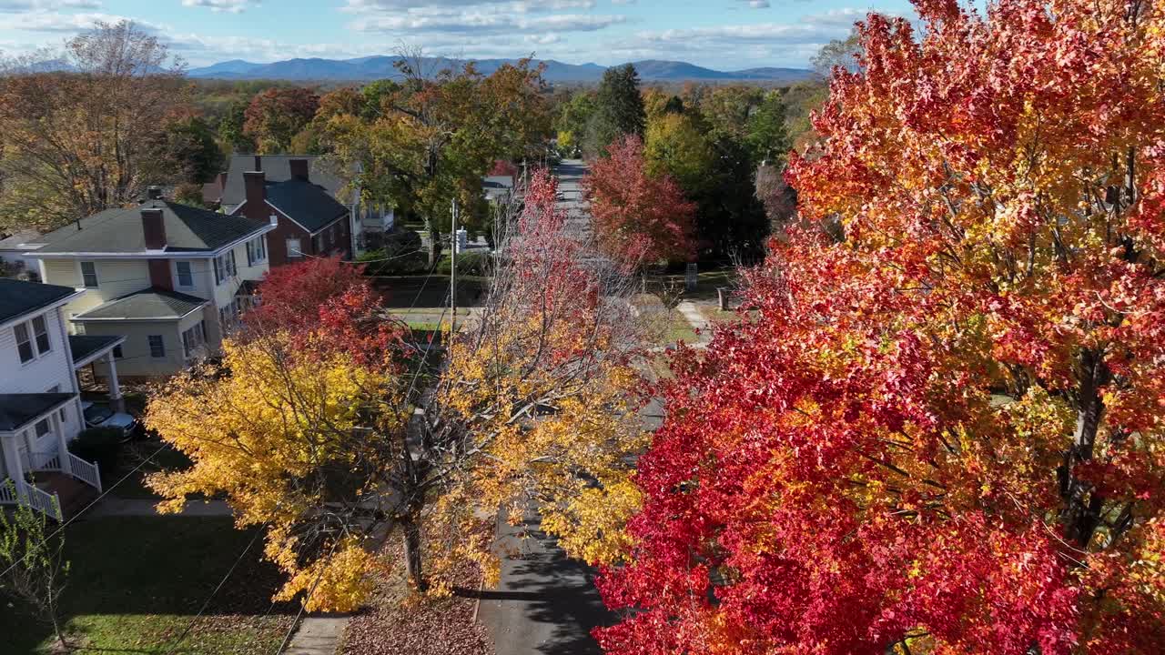 American neighborhood with vibrant fall foliage reveals, tree-lined streets, and distant mountain views captured on a bright and crisp midday autumn afternoon