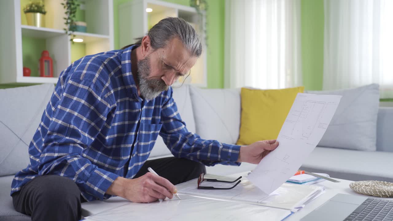Middle Aged Man Using Laptop Computer At Home Working Remotely.
