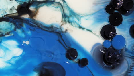 fondo de arte abstracto de burbujas de pintura azul y negra estallar y girar