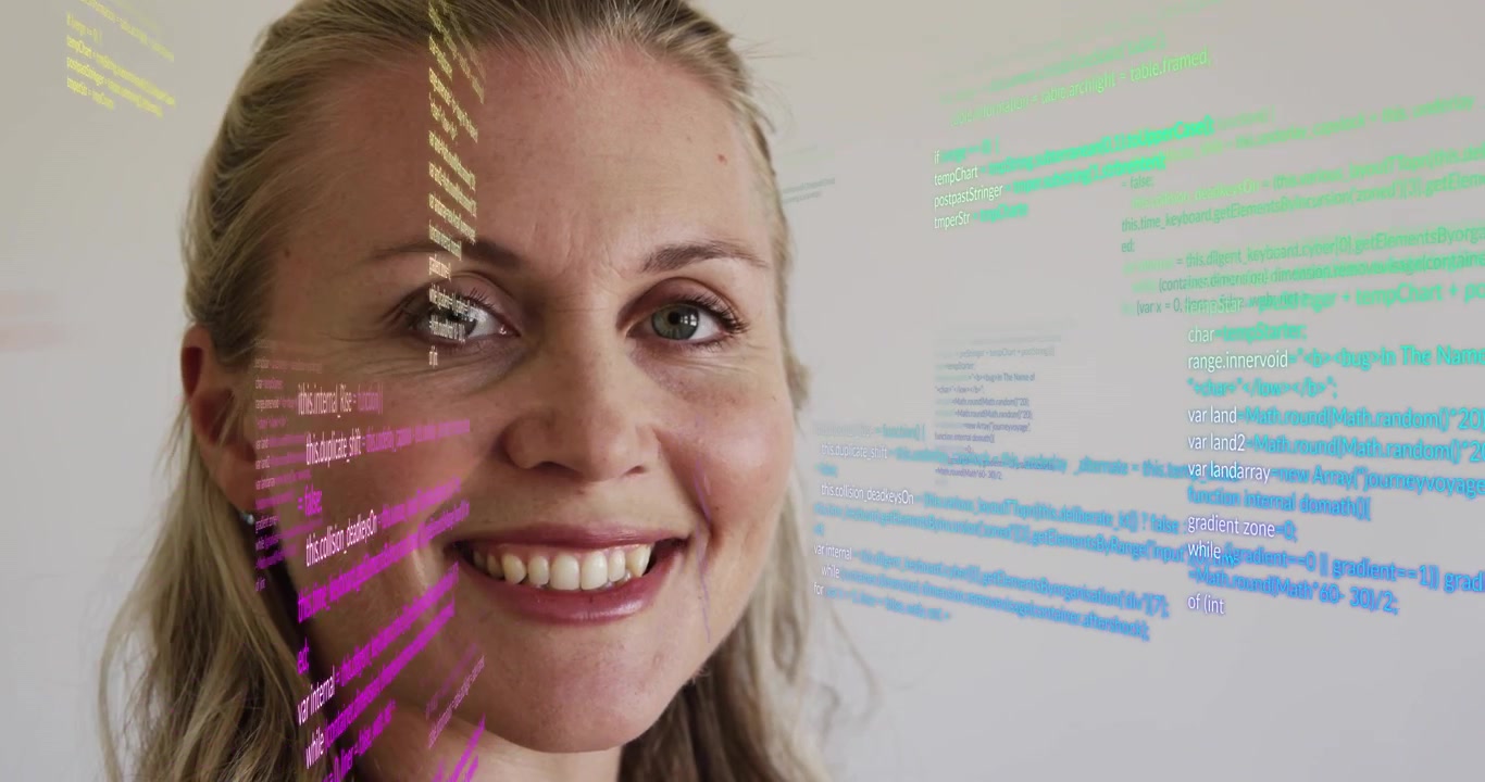 Donna del settore tecnologico che osserva flussi di codice colorati in arrivo pulsare su una parete luminosa, illustrando il cambiamento tecnologico.