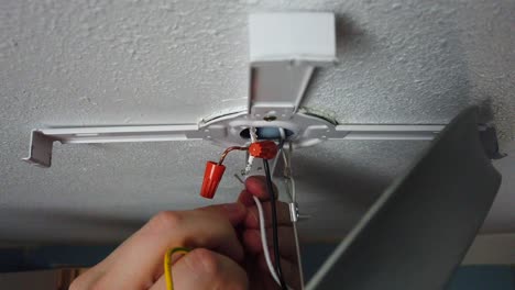 jugando con los cables de una nueva luz que se está instalando y retorciendo juntos