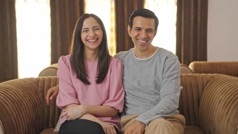 happy indian couple laughing towards the camera