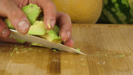 sliced avocado chunks are picked up with the use of a knife after chopping