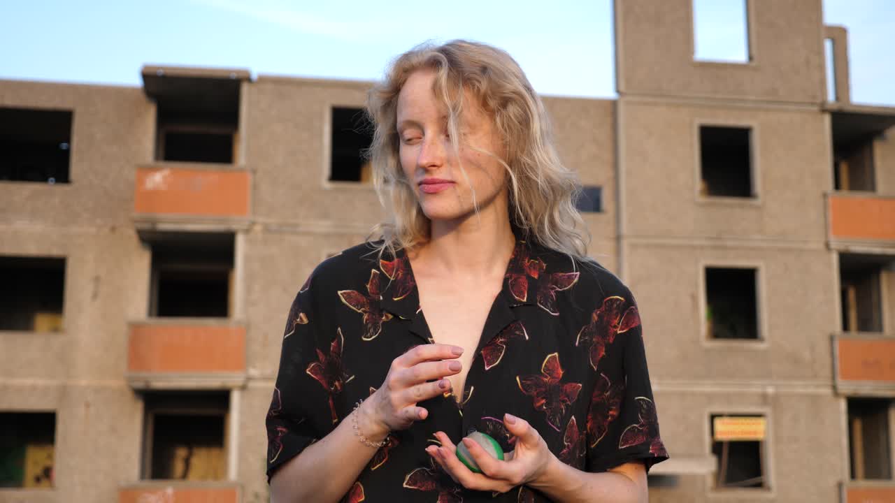 공을 가지고 놀고 카메라에 미소를 짓는 세련된 금발의 여자