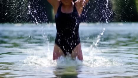 joyful summer moments: a young woman enjoys refreshing water play in nature, embracing the beauty and serenity of the outdoors with laughter and fun