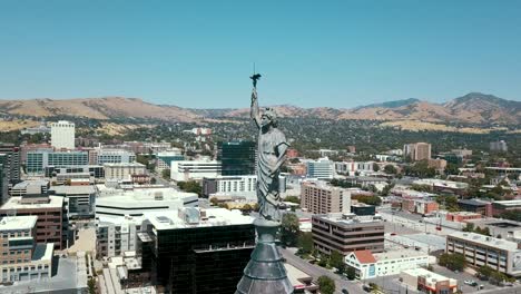 estatua de miss columbia en la ciudad de salt lake con horizonte y rascacielos