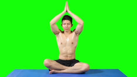young muscular man doing yoga and meditating