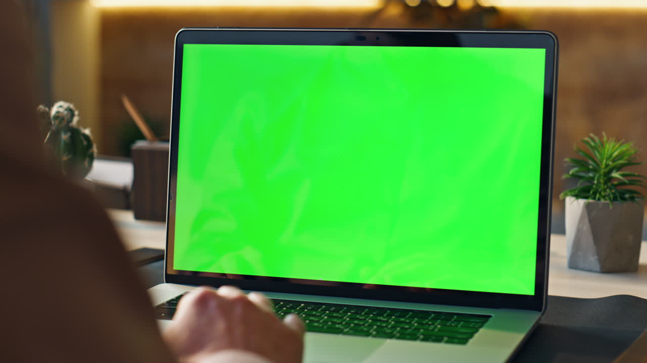 trabajador desplazamiento touchpad pantalla verde portátil en el lugar de trabajo de la oficina de cerca.