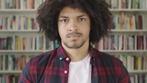 Retrato-Joven-Estudiante-Sonriente-Estantería-Biblioteca-Universidad