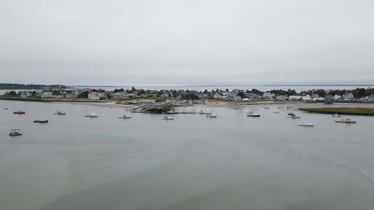 Scarborough, maine coastline with moored boats and calm waters under an overcast sky, aerial view
