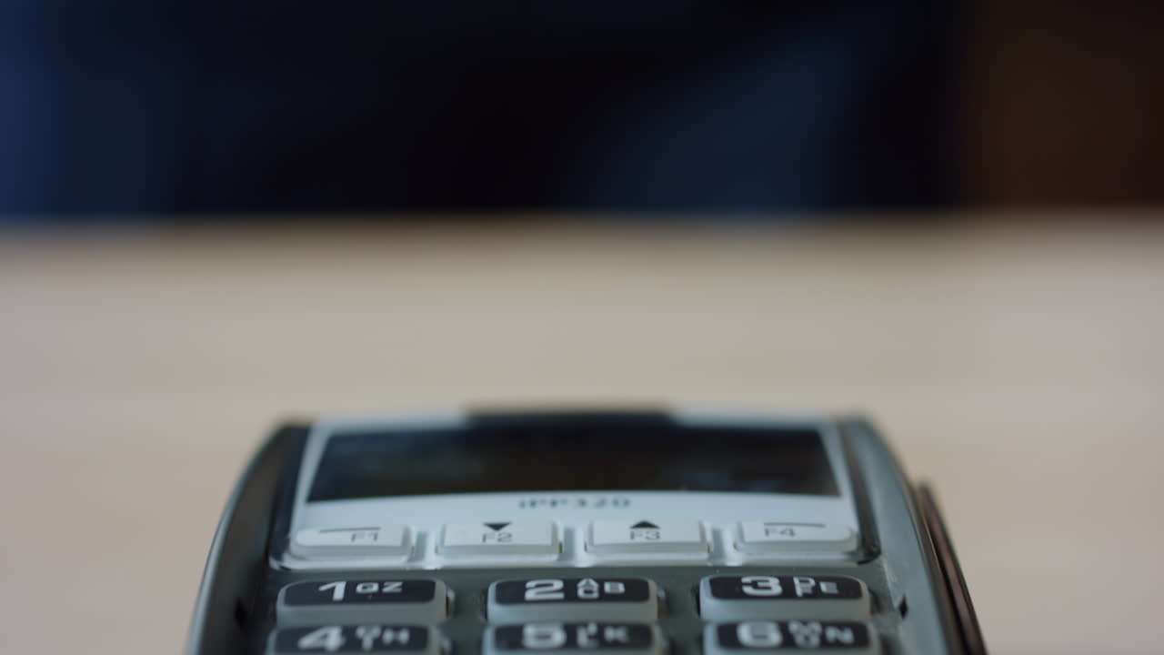 Closeup contactless card transaction on terminal. Man making cashless payment.