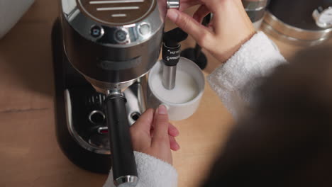 woman making a cappuccino with a coffee machine